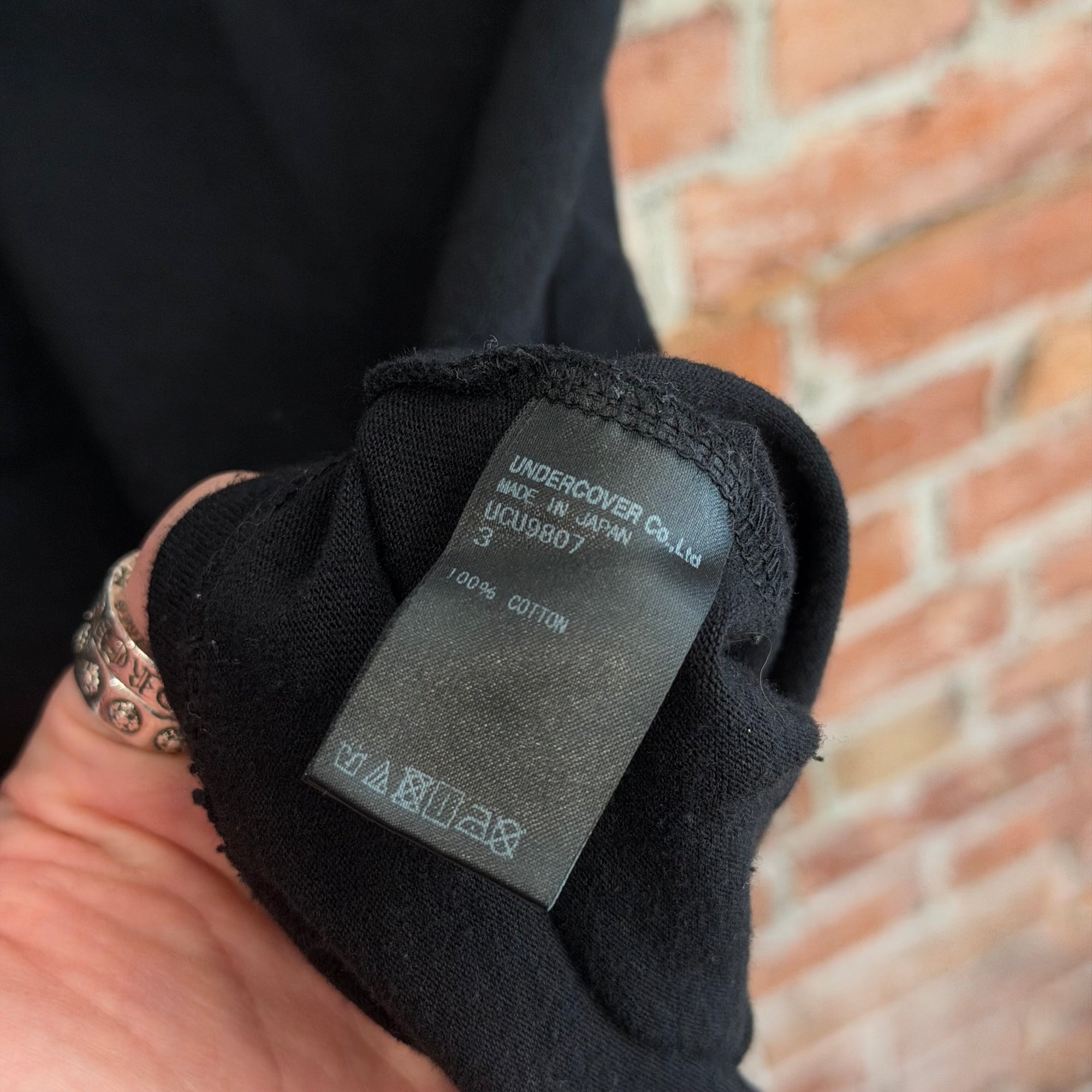 UNDERCOVER MADSTORE WE MAKE NOISE NOT CLOTHES TEE ‘BLACK’