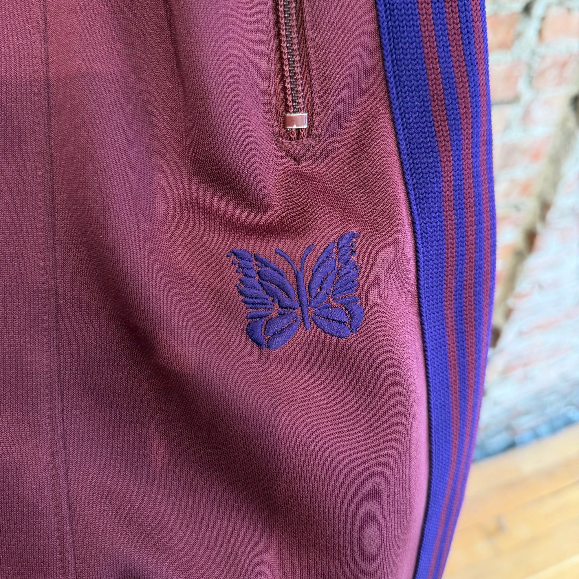 NEEDLES WIDE HD TRACK PANTS ‘MAROON/PURPLE’