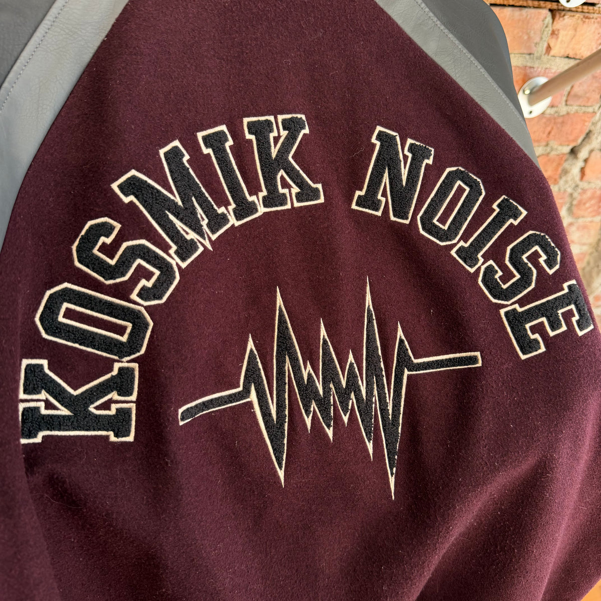 GU X UNDERCOVER KOSMIK NOISE VARSITY JACKET ‘BLACK/MAROON’