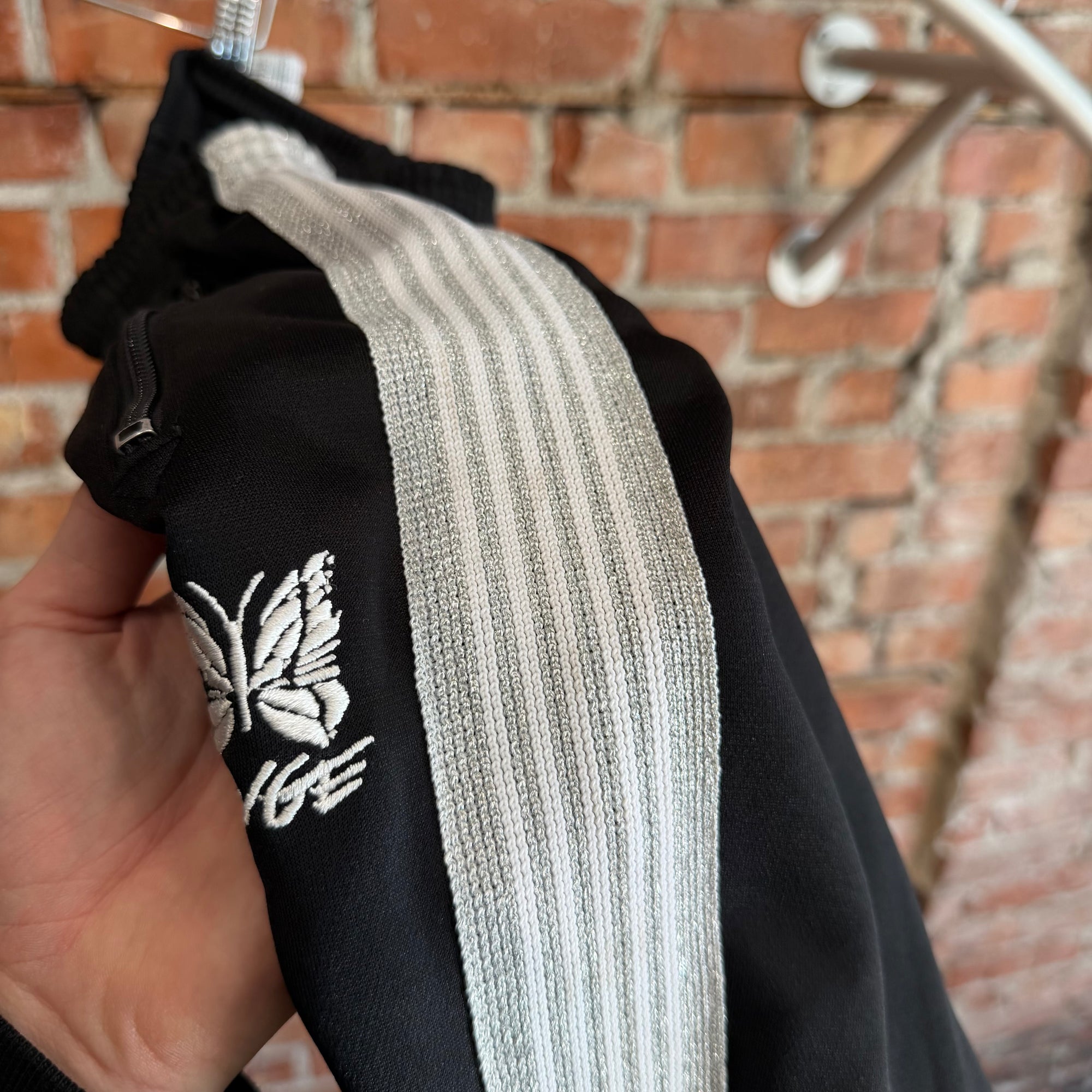 NEEDLES X AWGE TRACK PANTS ‘BLACK/SILVER’